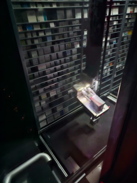 Kommisionier Automat Ein Regal mit Schachteln und einem Greifer
