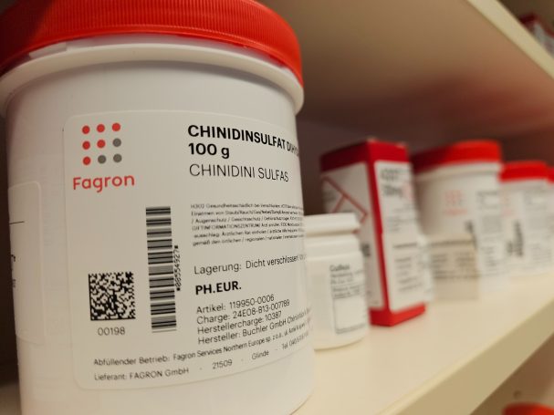geprüfte Rohstoffe Behälter mit Chromgel, Beschriftungen und QR-Codes sichtbar, auf Regal platziert.